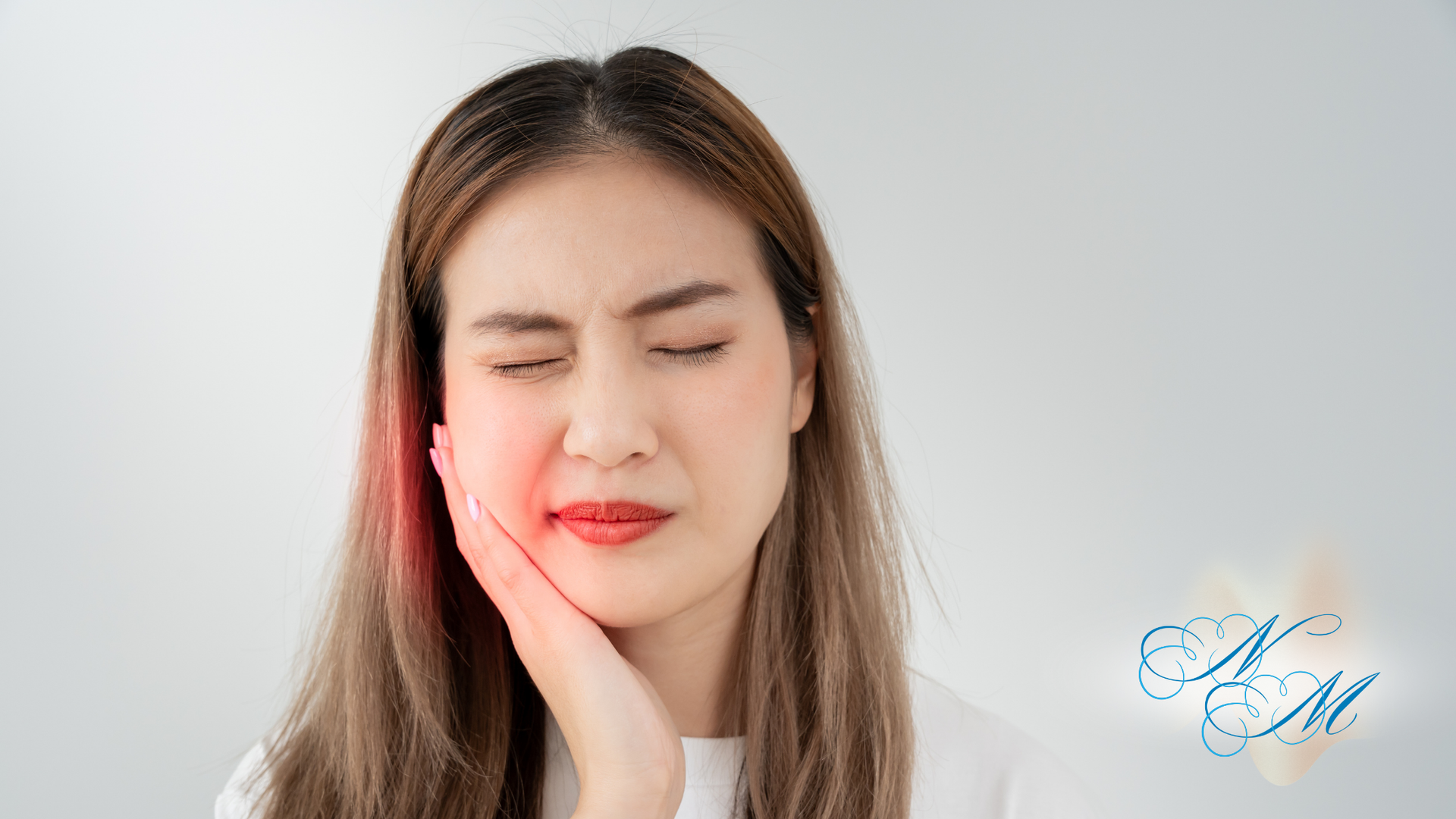 A woman is holding her face in pain because of a toothache.