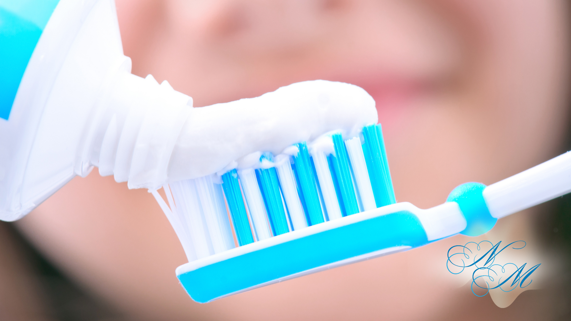 A person is applying toothpaste to a toothbrush.