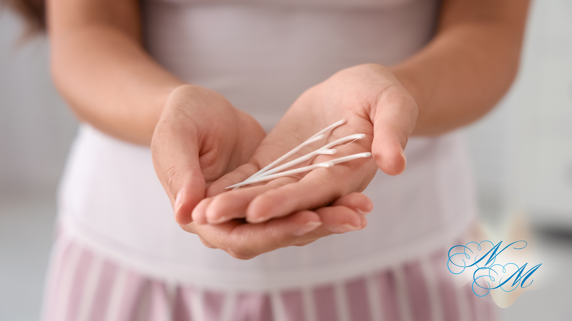 Hands holding a white menstrual pad against a pink background
