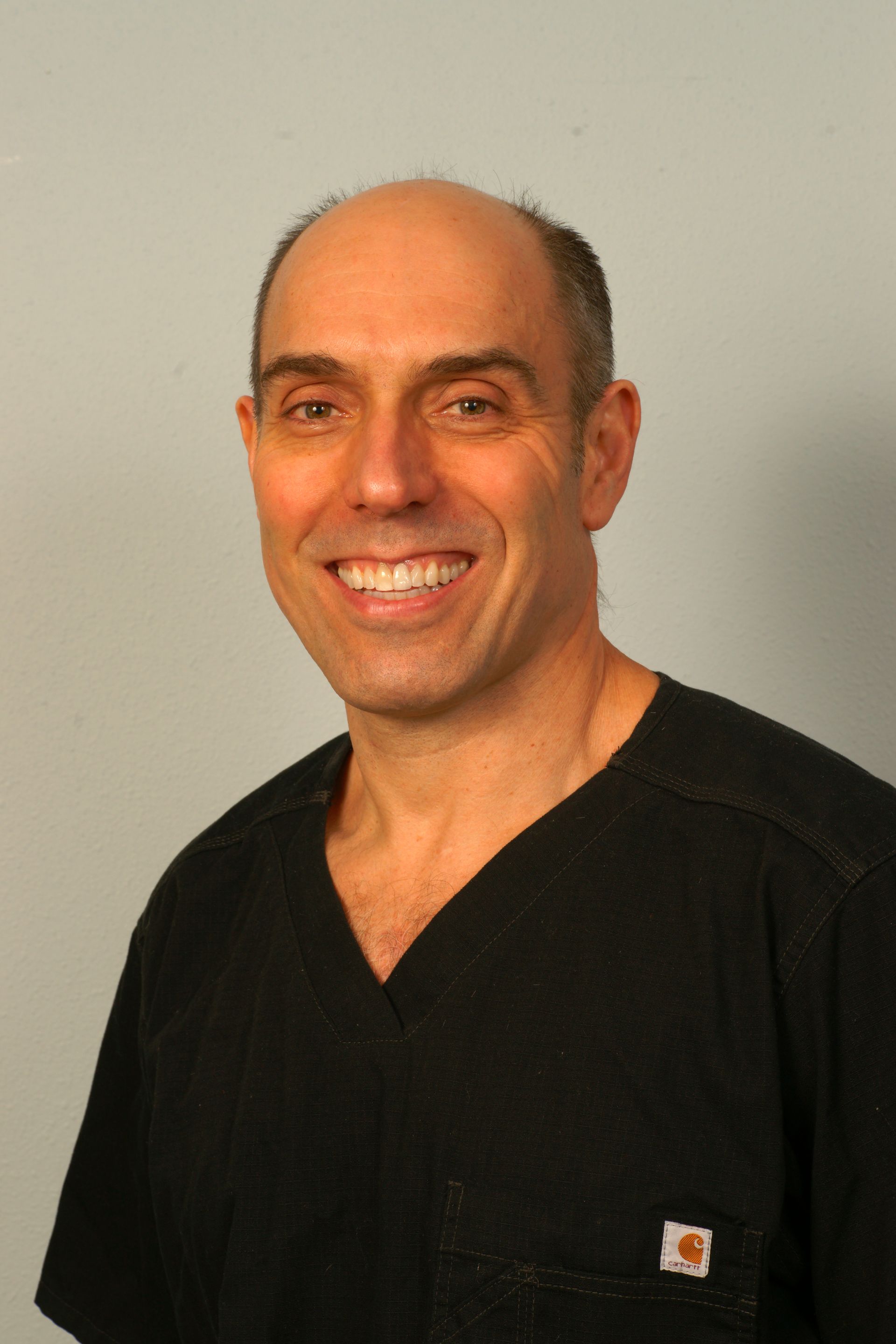 A woman in a blue shirt is smiling for the camera.