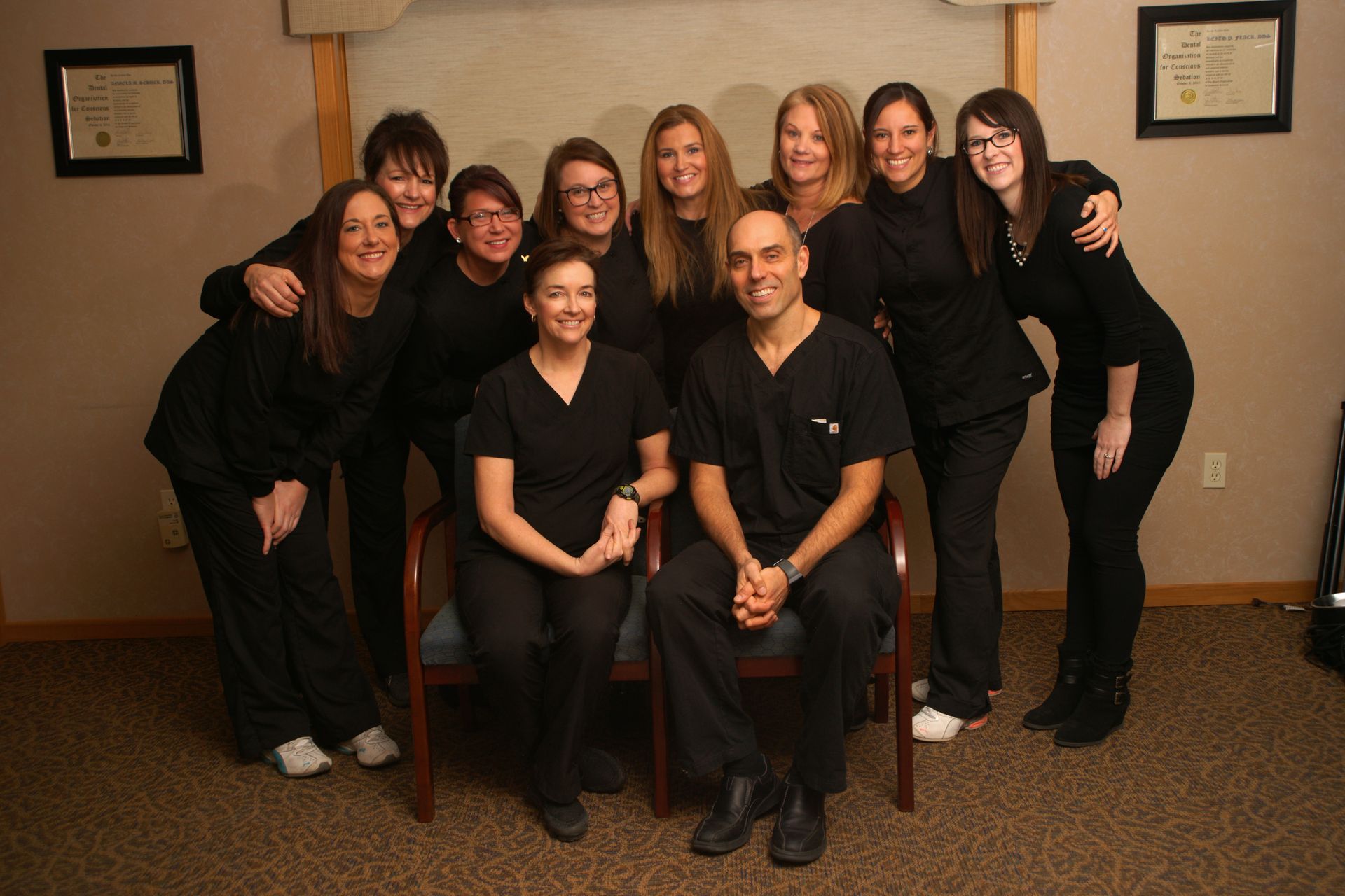 A group of people are standing in a room holding drinks.