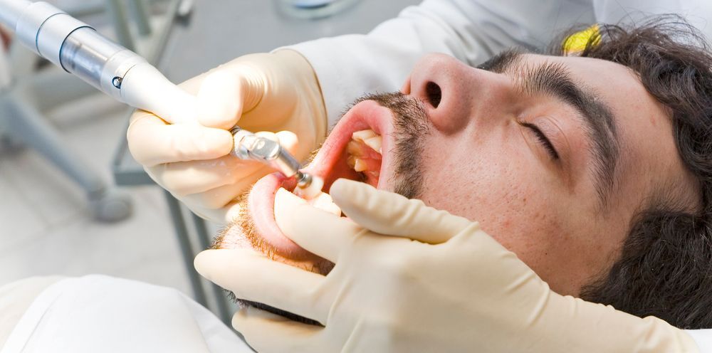 A man is getting his teeth examined by a dentist.
