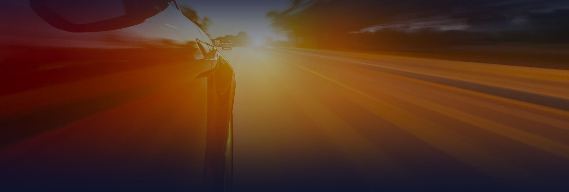 Two semi-trucks on a highway, the orange truck closer with a white trailer, one blue in the distance | Jim's Auto Repair & Towing