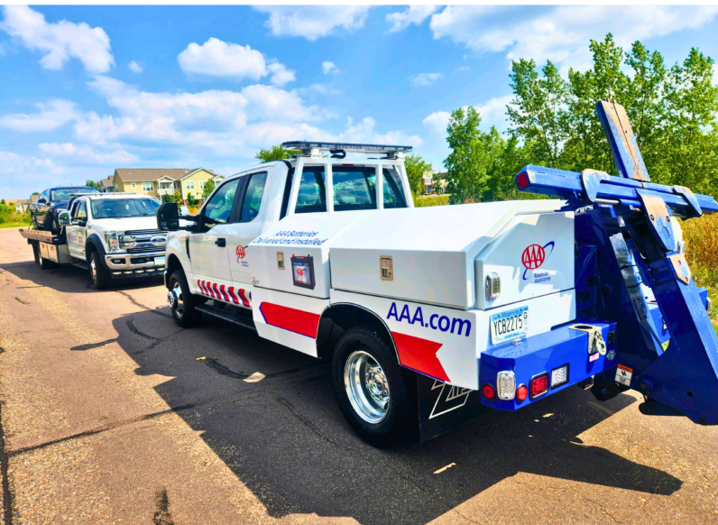 A tow truck is parked on the side of the road.
