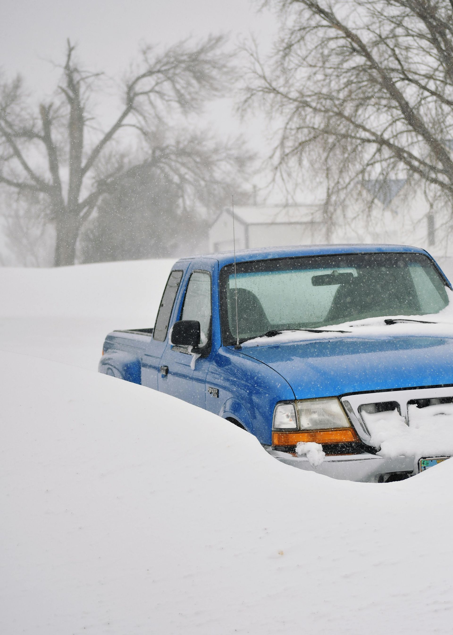 A white tow truck is driving down a dirt road.
