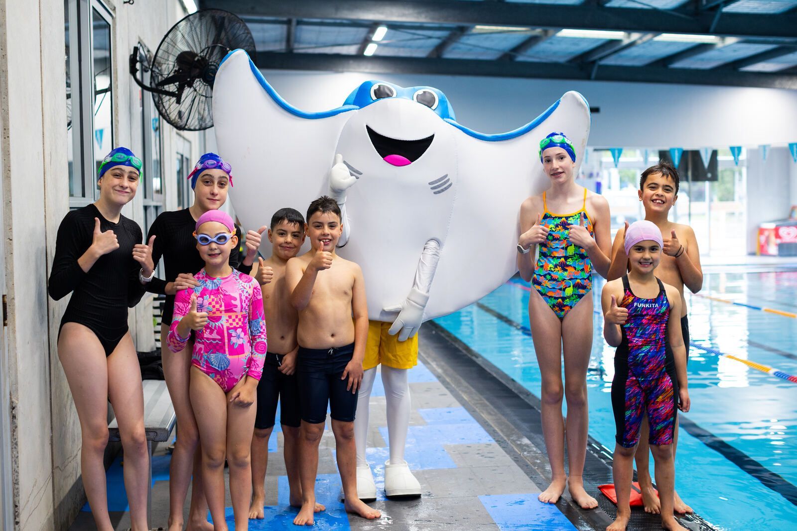 Happy swimmers with Shawn's Swim School mascot