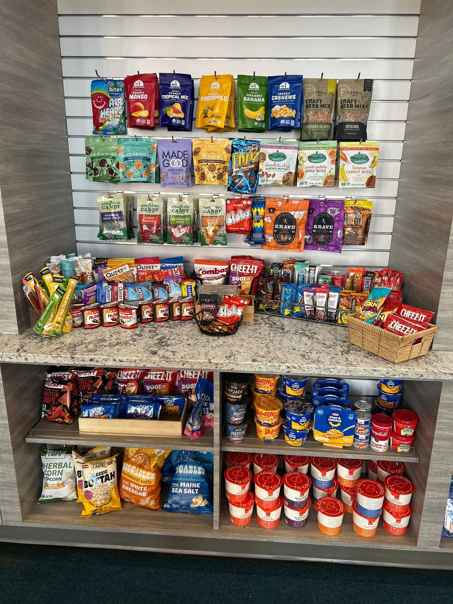 Snack display with various packaged snacks on shelves.