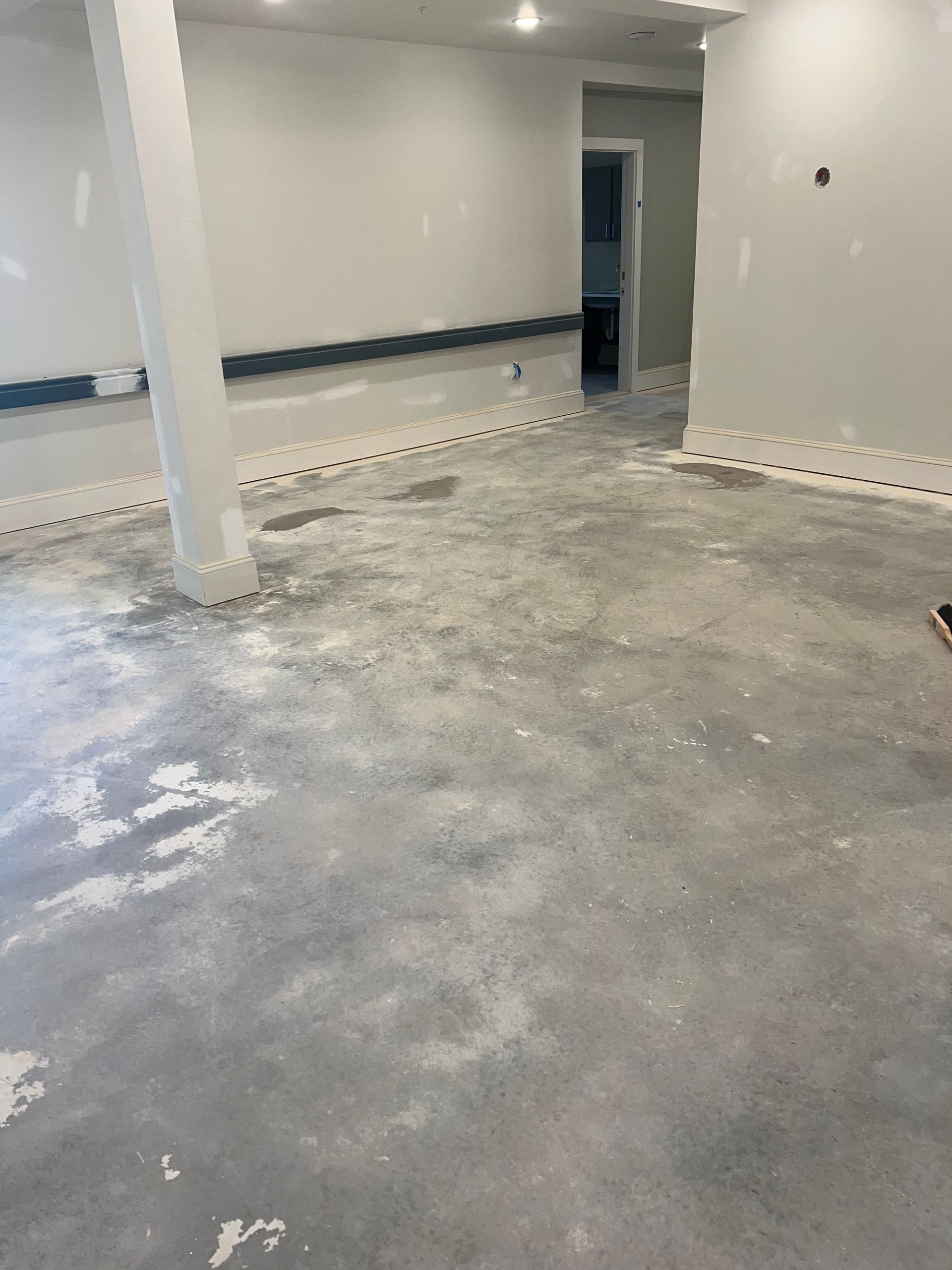 An empty room with a concrete floor and white walls.