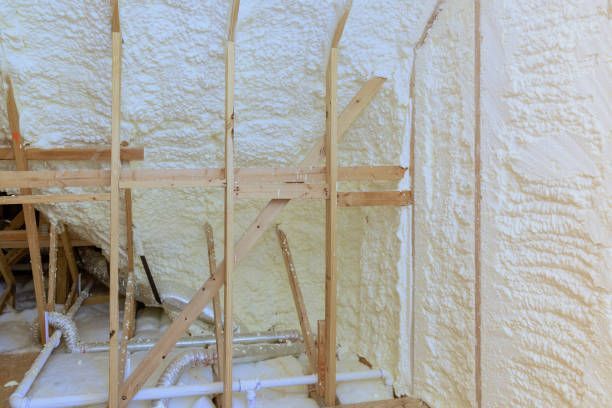 Insulated attic with wooden framing and foam insulation.