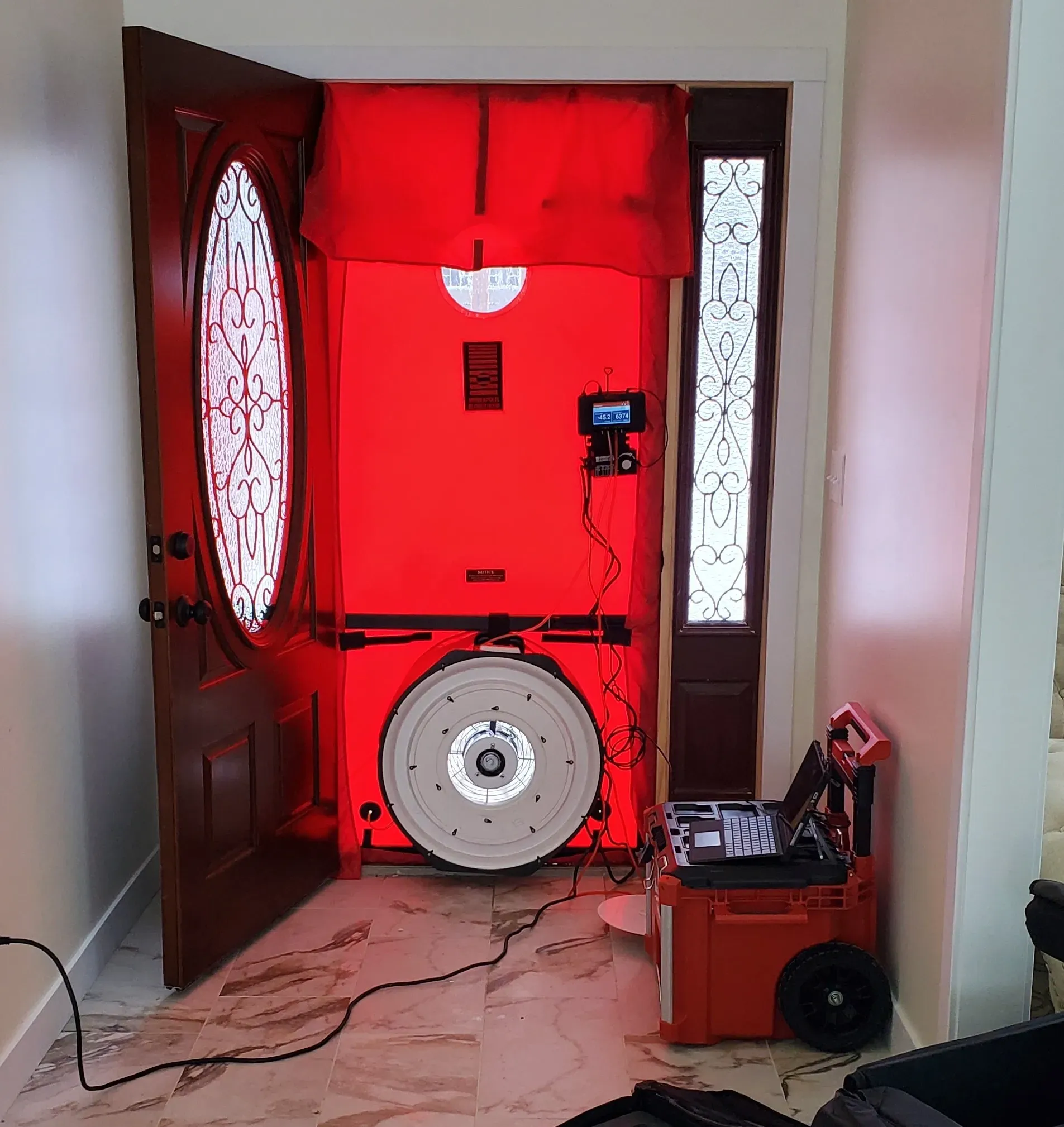 A room with a red door and a white wheel