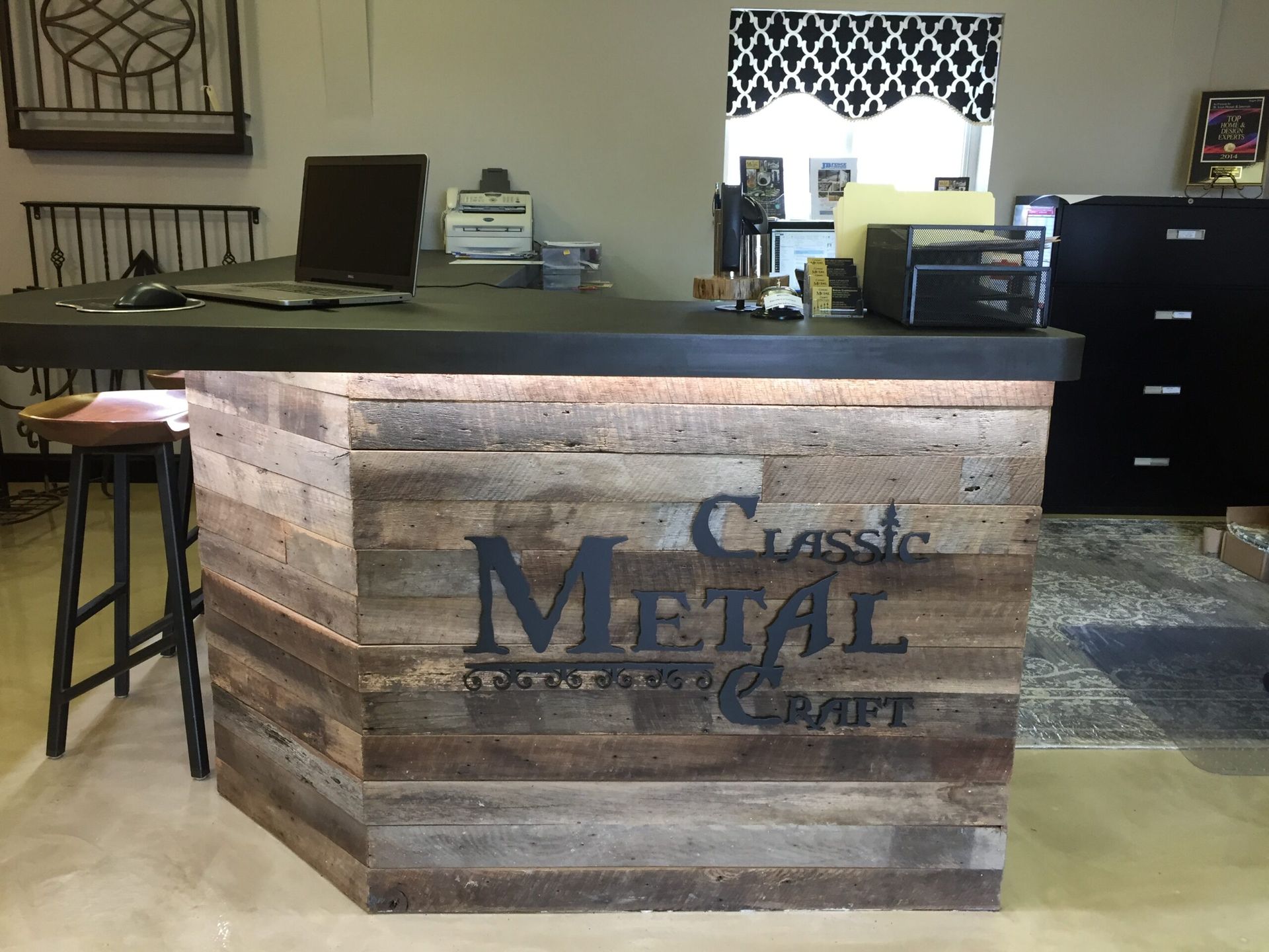 Rustic metalcraft shop interior with a wooden front counter and stools.