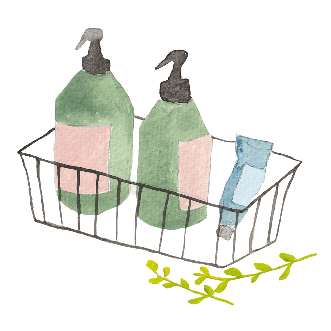 Two green pump bottles and a blue tube in a wire basket, with a small green sprig beside it.