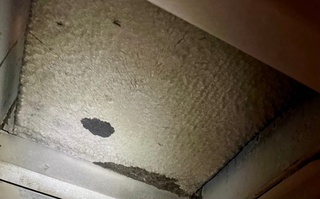 A close up of a ceiling with a hole in it.