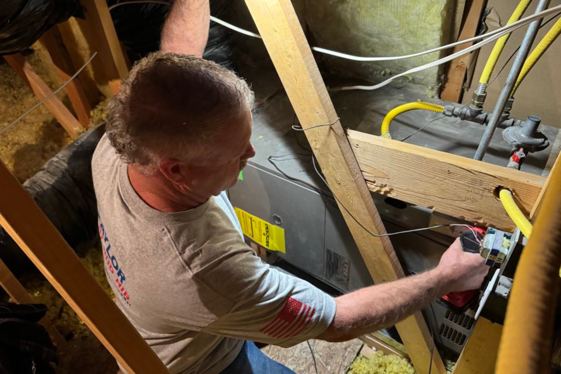 A man is working on an air conditioner outside of a house.