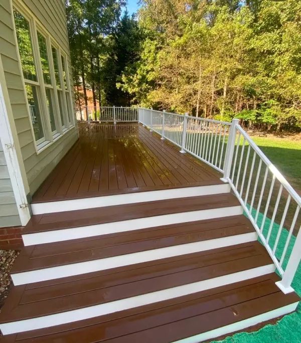 A wooden deck with white stairs and a white railing