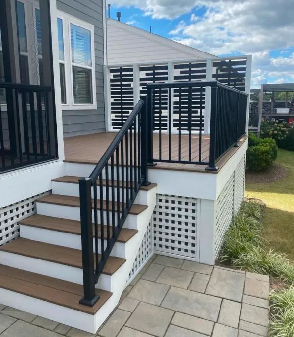 Stairs leading up to a deck with a black railing