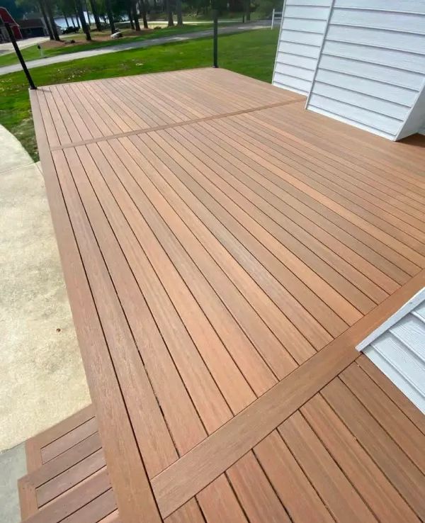 A wooden deck with a white house in the background
