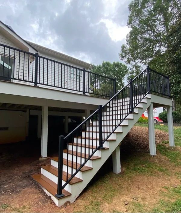 A white house with stairs leading up to the deck