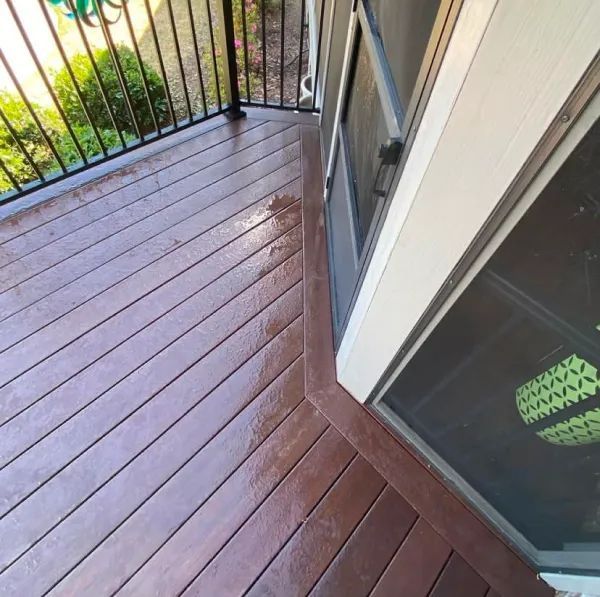 A balcony with a screen door and a wooden deck
