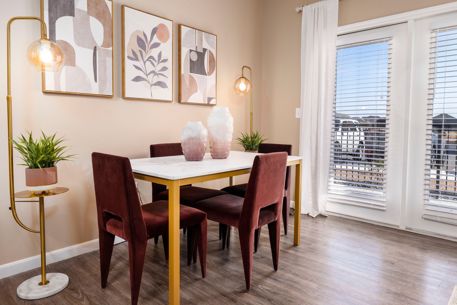 A dining room with a table and chairs and a large window.