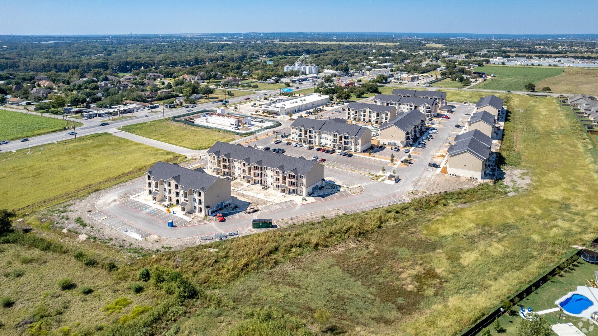 An aerial view of a residential area with a lot of houses and a pool.