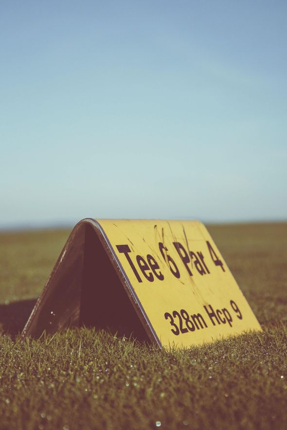 Yellow golf course sign labeled 