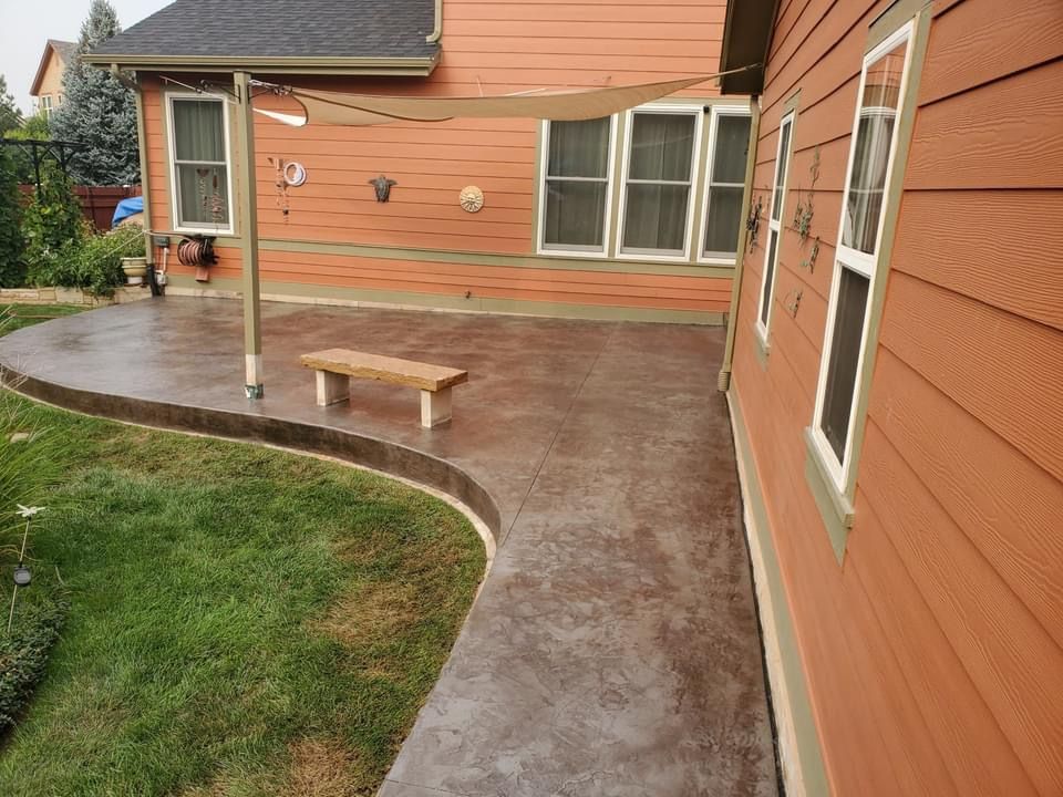 A patio with a bench and a canopy in front of a house.