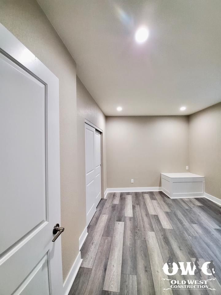 A large room with a wooden floor and white walls.