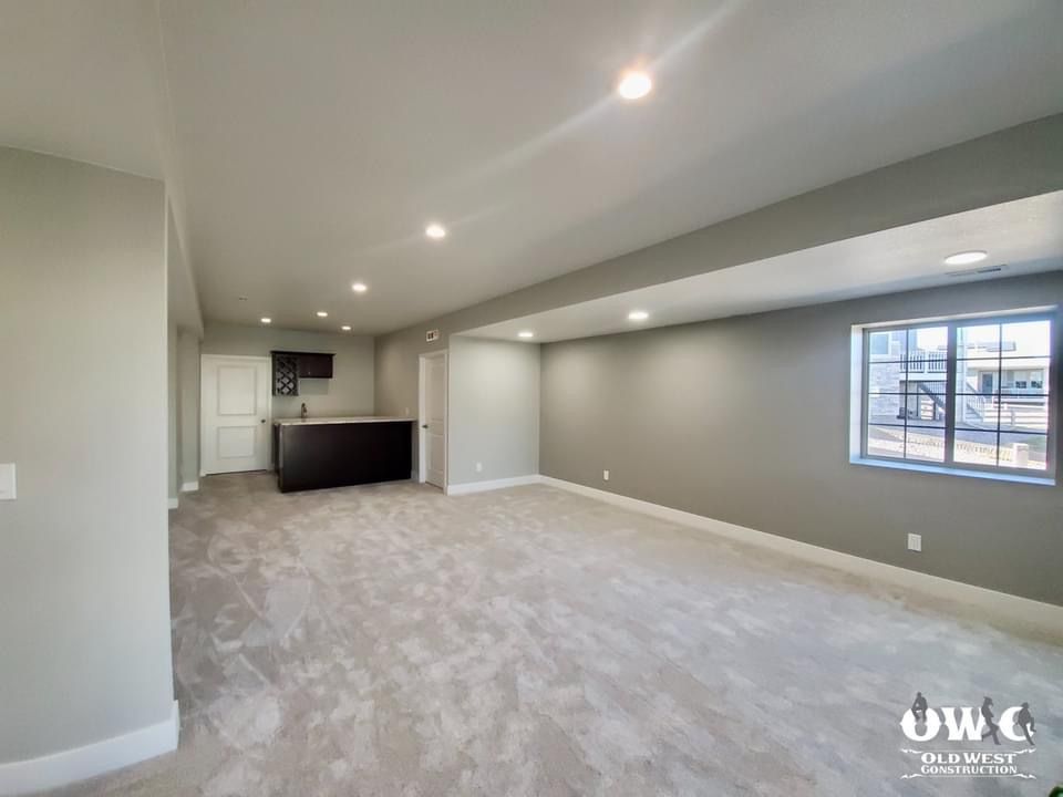 An empty basement with a bar and a window.