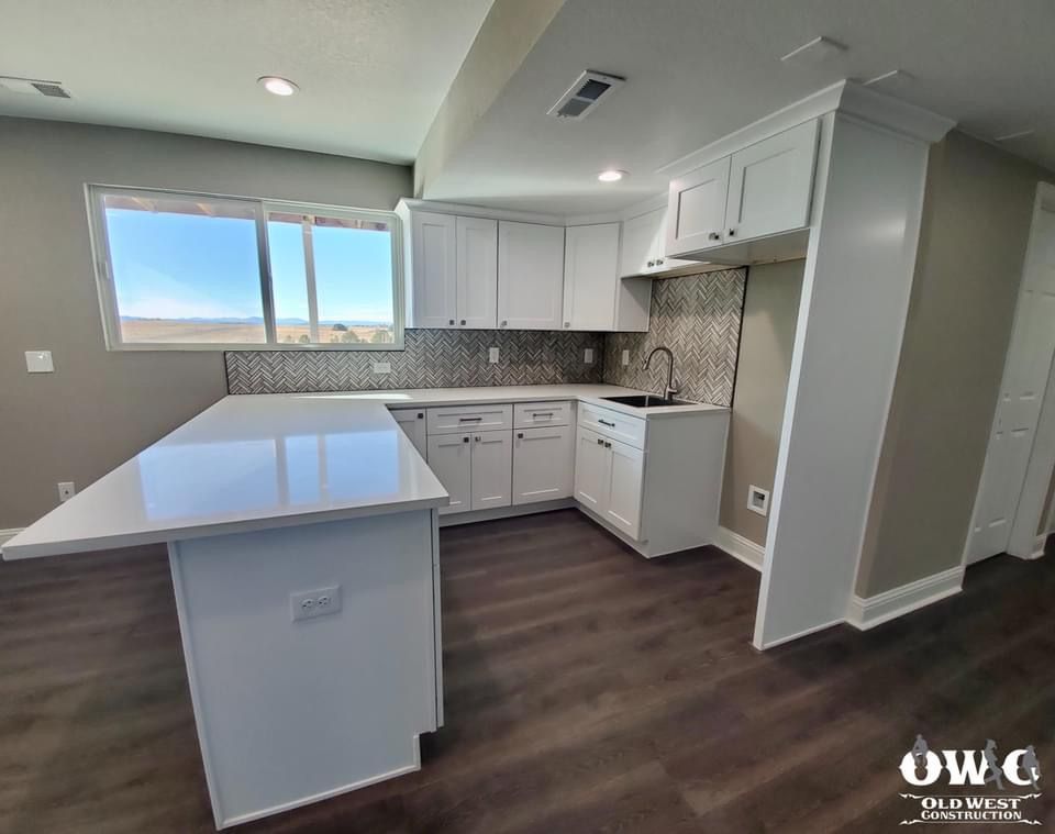 A kitchen with white cabinets and a large island.