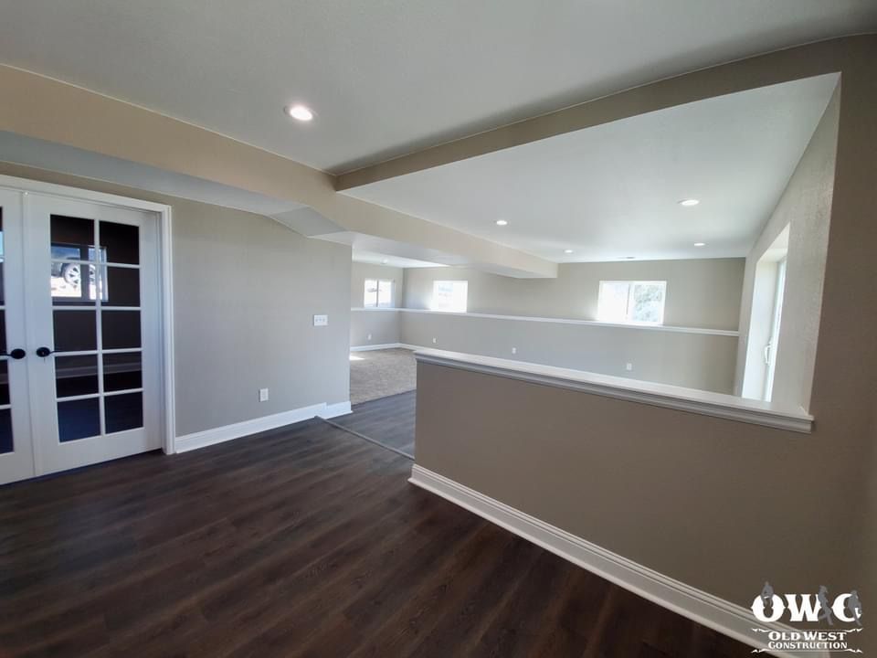 An empty room with hardwood floors and a staircase leading to the second floor.