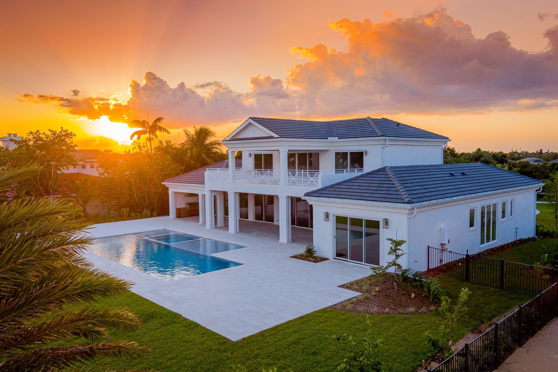 Luxury white house with pool at sunset.