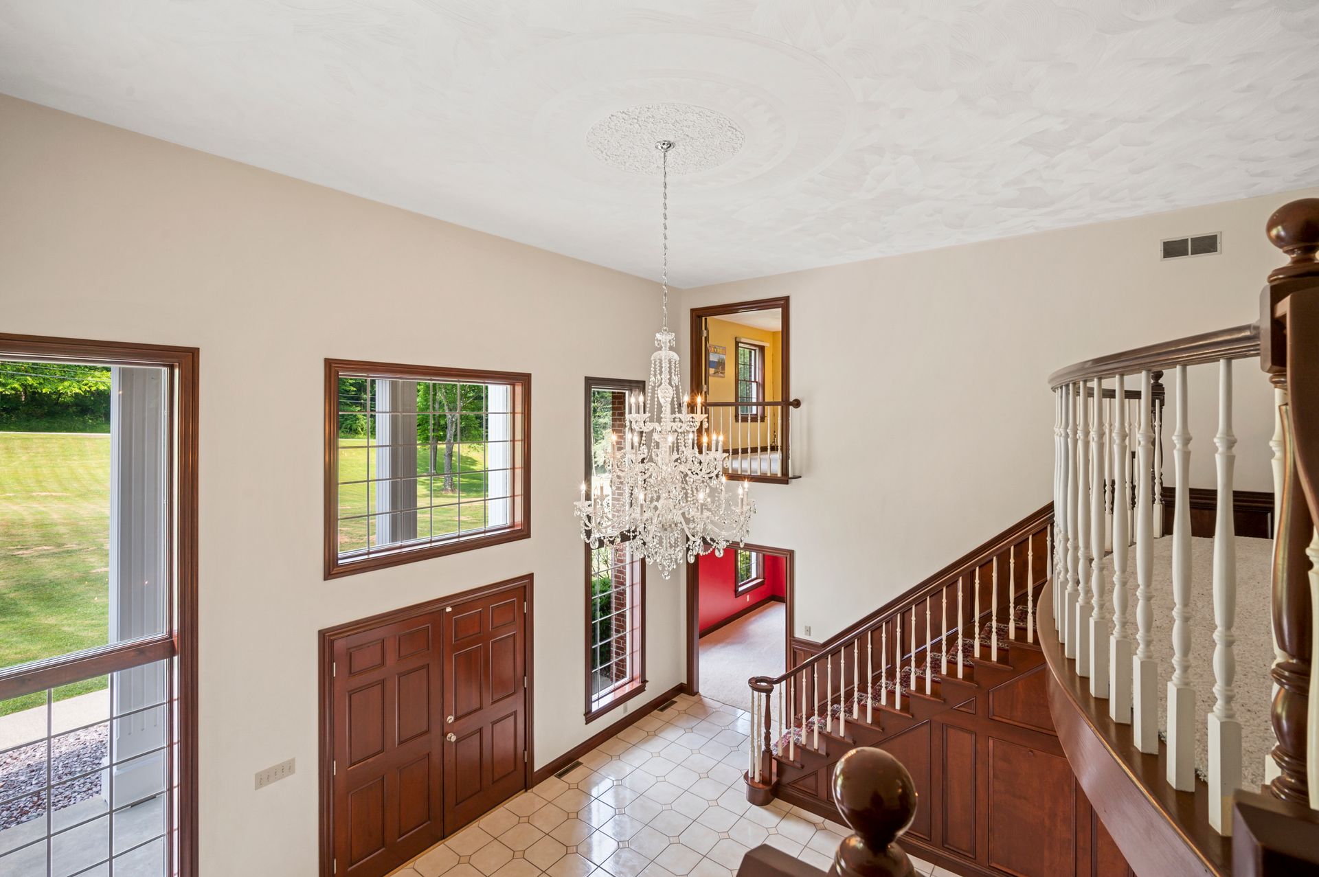 A staircase in a house with a chandelier hanging from the ceiling.