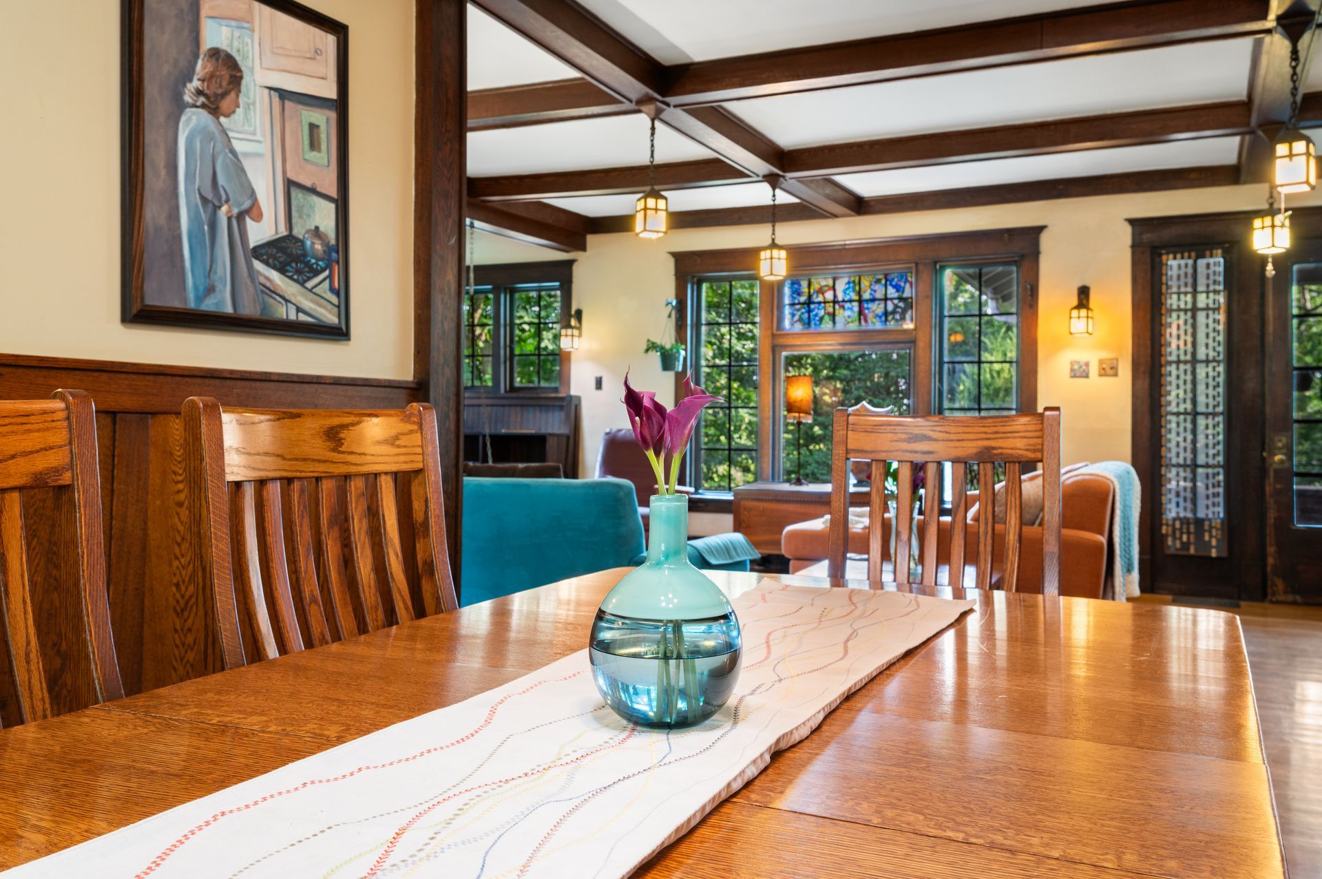 A dining room table with a vase of flowers on it.