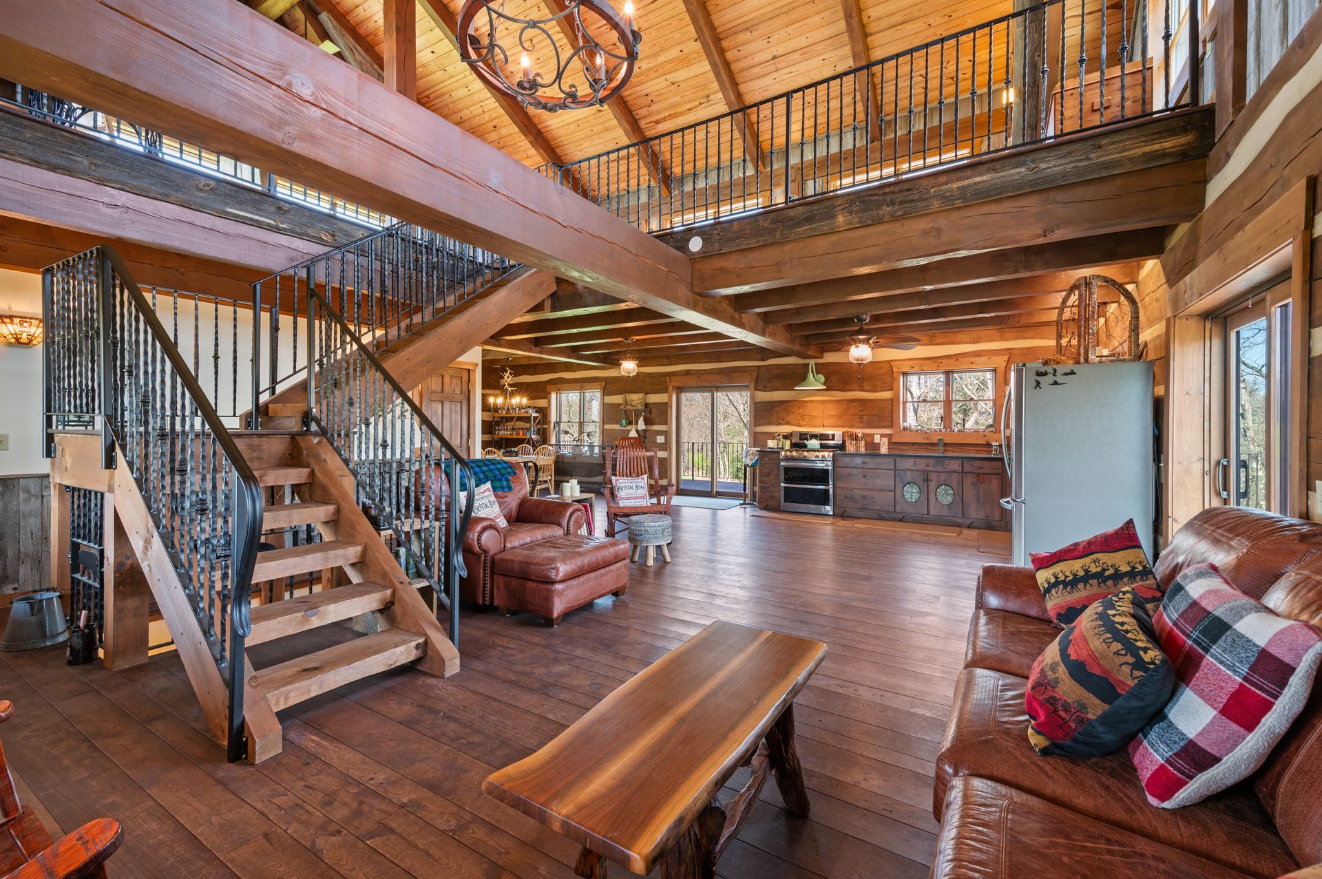 A living room filled with furniture and stairs in a log cabin.