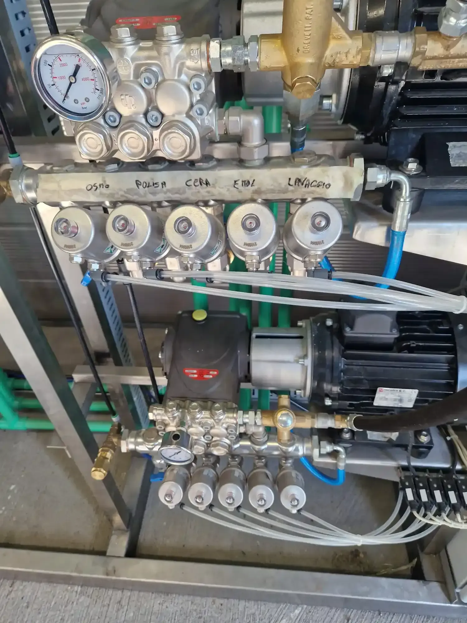 Sistema di pompaggio industriale con manometri, valvole e motore, montato su un telaio metallico.