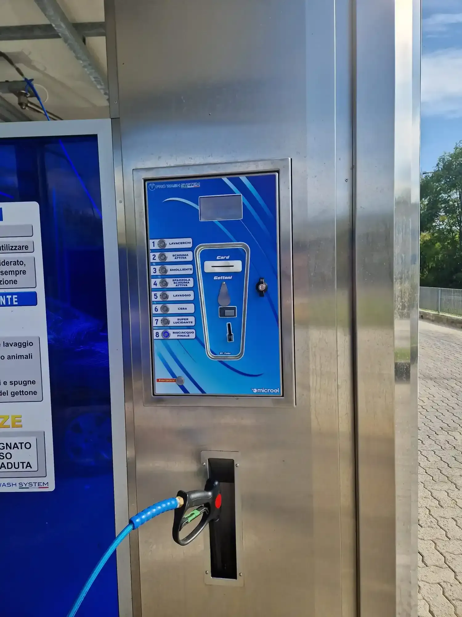 Pannello di controllo per autolavaggio blu e argento con tubo e ugello blu.