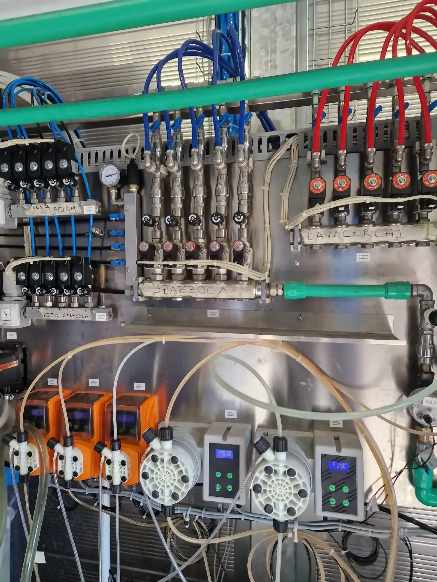 Quadro di controllo industriale con pompe, valvole e tubi in configurazione di fabbrica.