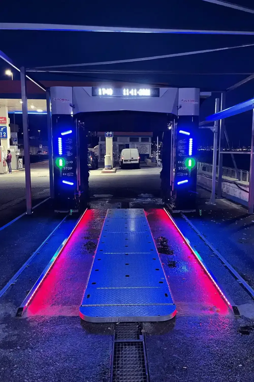 Autolavaggio illuminato di notte con luci blu e rosse.