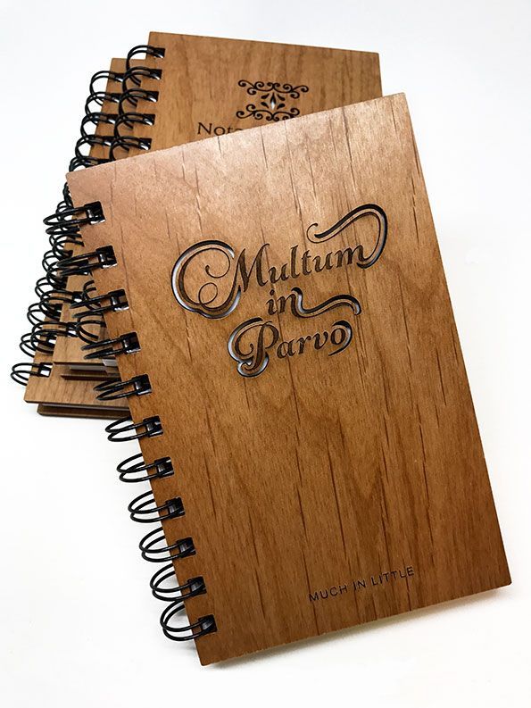 a stack of wooden notebooks with the words multum in parvo written on them