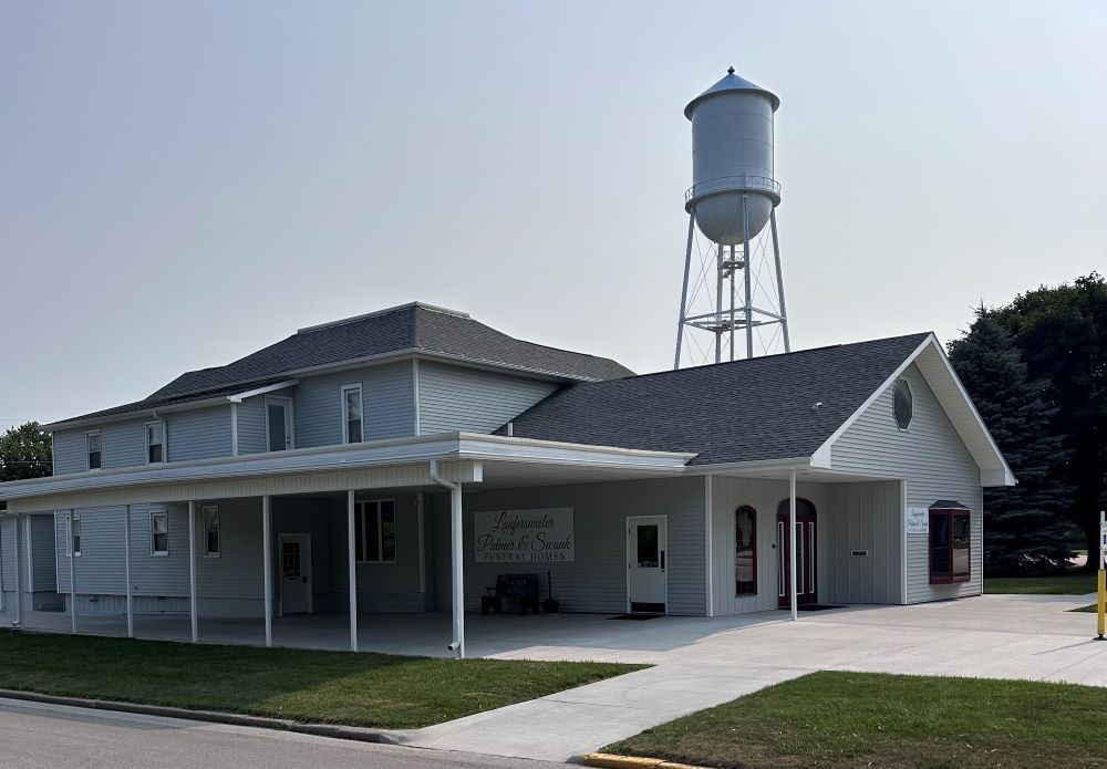 A large white house with a water tower on top of it