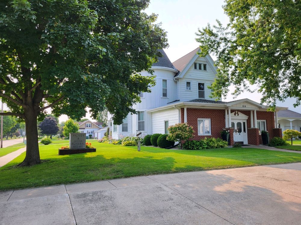 A large white house with a large lawn in front of it