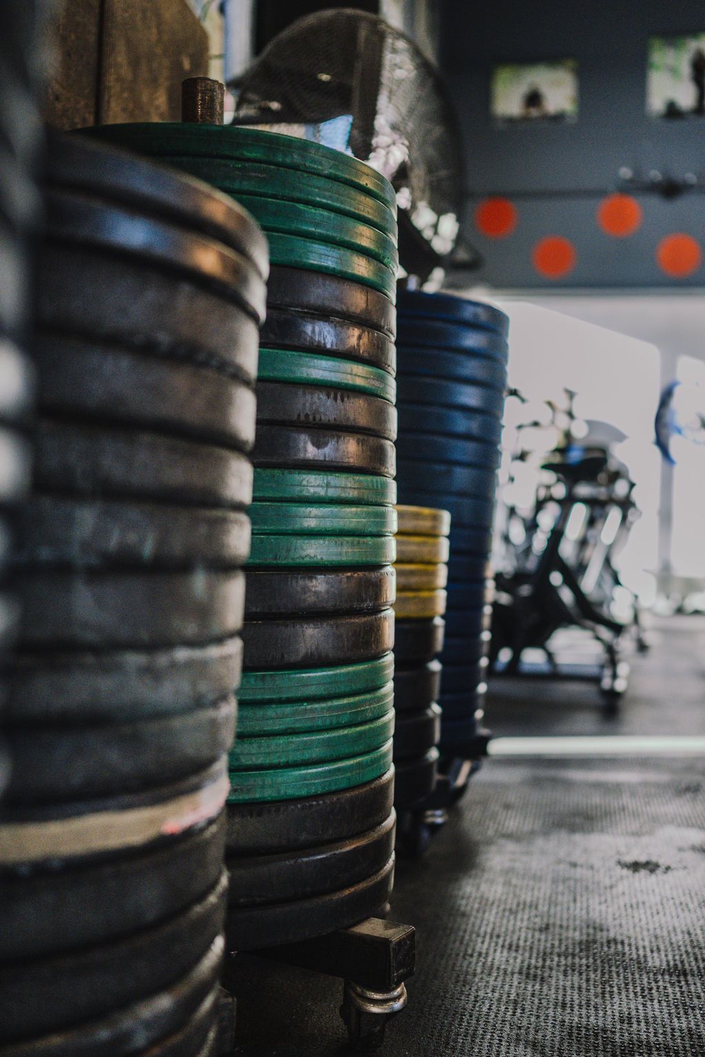 Weight plates stacked in a gym, with various colors.