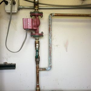 A copper pipe with a red pump attached to it