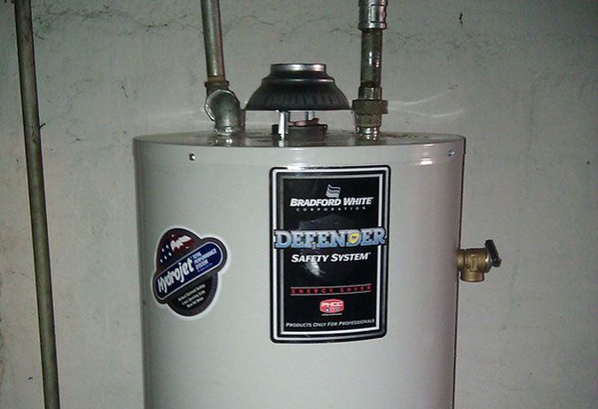 A white water heater with a label that says defender