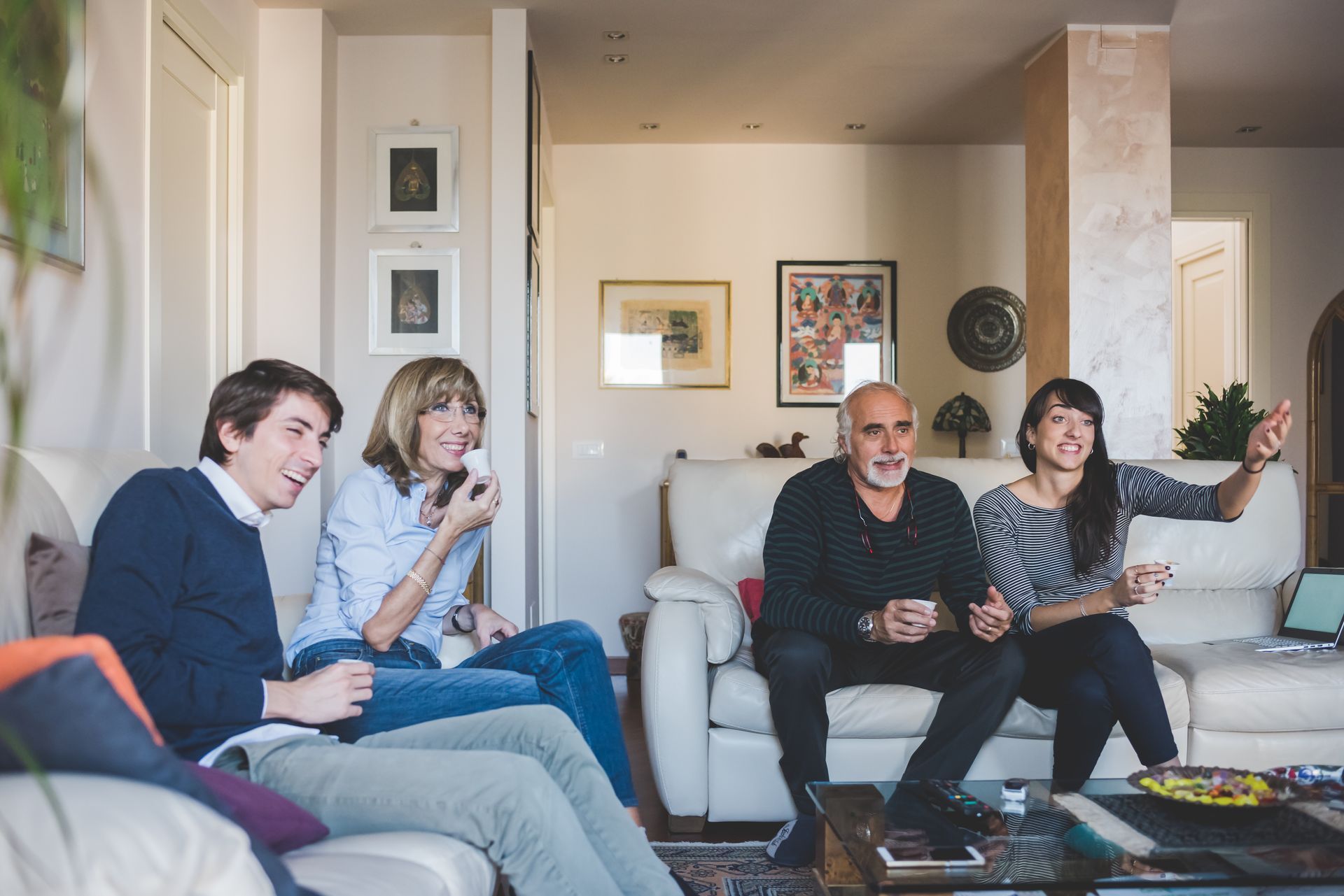 A family is sitting on a couch in a living room watching tv.
