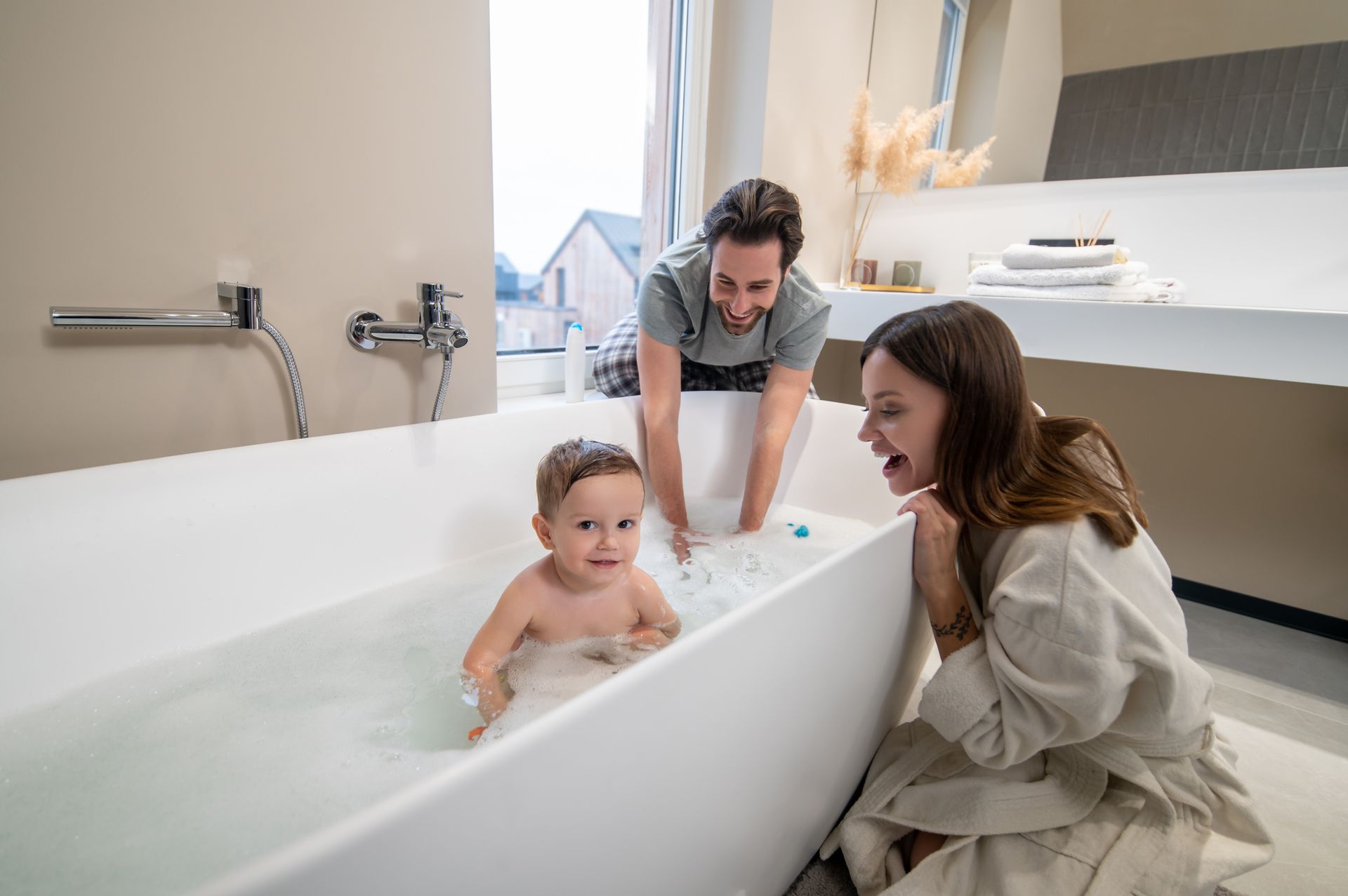 A family is taking a bath together in a bathtub.