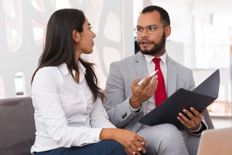 a man and woman sitting on a couch talking to each other
