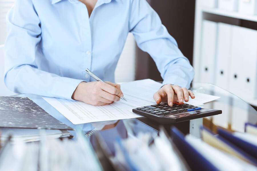 a woman sitting at a desk with a calculator