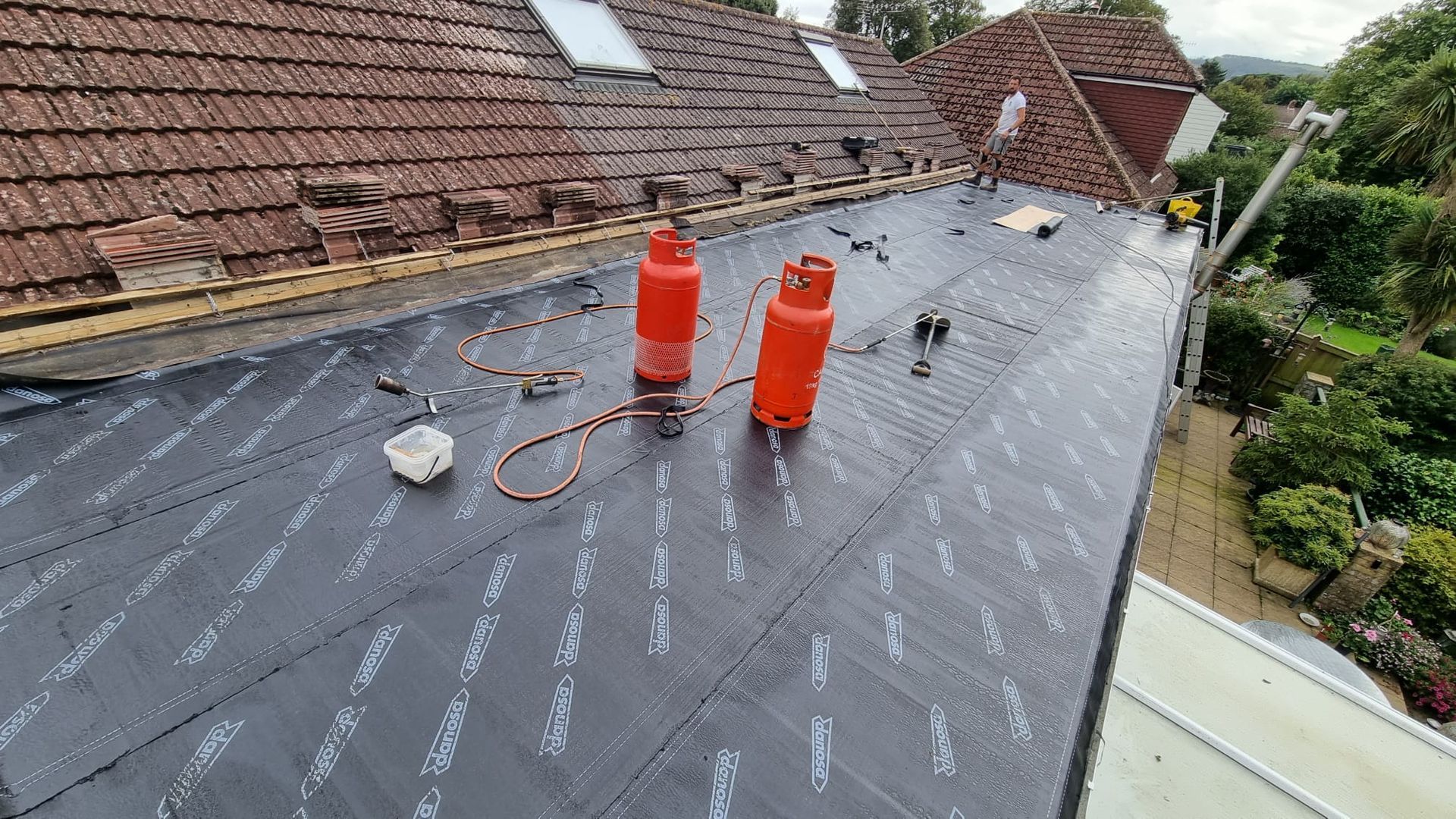Two gas bottles are sitting on top of a roof.